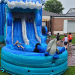 Kids playing on backyard inflatable water slide rental as